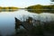 Empty footbridge with a bench on a lake at sunrise