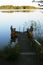 Empty footbridge with a bench on a lake at sunrise