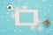 Empty frame, snowflakes, gifts, festive decorations on pastel blue background. Christmas, winter, new year concept