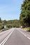 Empty freeway against blue sky and woods