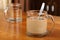 Empty and full transparent glass cup with coffee and milk on a wooden table