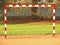 Empty gate. Outdoor football or handball playground, light red crushed bricks surface on ground