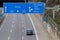 Empty German Autobahn in Dusseldorf with blue street signs and white arrows without traffic jam shows multiple lane highway ready