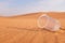 Empty glass of water on a desert land showing dehydration and water shortage concept