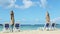 Empty golden sand seashore with long beach chairs and closed umbrellas