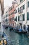 Empty gondolas moored on a narrow canal in Venice, Italy.
