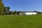 Empty grass for sport field activities in college with blue sky. University campus green forest field.