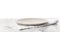 Empty grey plate and napkin on table against white background