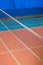 Empty gym with a stretched net for volleyball, against the background of orange and blue floor. Space for text. The concept of