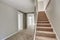 Empty hallway interior with gray walls and staircase.