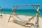 Empty hammock made of mesh on wooden poles on the beach for tourists