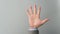 Empty hand palm in businessman grey suit on grey background