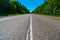 Empty highway with green forest on both sides