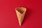 Empty ice cream cone on the red background, top view flat lay. Minimalism style creativity concept