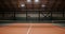 An empty indoor tennis court with orange rubber covering and stretched net