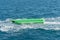 empty inflatable green banana boat in the sea. Banana Boat for fun on water surface in summer day - banana boat at the sea