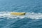 empty inflatable yellow banana boat in the sea. Banana Boat for fun on water surface in summer day - banana boat at the sea