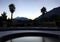 Empty Inner yard of a hotel with the pool and palms on the background of the mountains twilight view