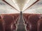 Empty interior cabin of an Airbus A320 Neo with red seats and trim. Many airlines face dire straits as they face a worldwide