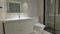 Empty Interior of modern gray bathroom with mirror, sink, toilet and shower with glass partition