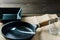 Empty kitchen utensil cup, plate, fork, frying pan, on the table still life setup.