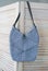 Empty knitted bag hanging on wooden door. Ad and buy concept