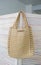 Empty knitted bag hanging on wooden door. Ad and buy concept