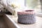 Empty knitted flowerpot cover on window sill with space for text