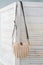 Empty knitted purse hanging on wooden door. Ad and buy concept