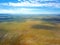 Empty Lake George nestled between a rural wind farm and farmland in Australia