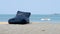 Empty large fabric bean bag chair on sandy beach