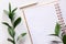 Empty lined notebook with green leaves and a wooden pencil