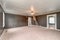 Empty living room with dark black walls white trim bright white carpet and ceiling with pull down ladder to attic