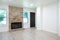 Empty living room with a fireplace, white walls and hardwood floor