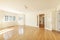 Empty living room with French oak hardwood floors, white lacquered wood door joinery with gold-edged French windows and French-