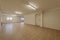 Empty living room of a ground floor residential detached house with tiled floors, French style windows and fire doors