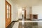 Empty living room of a house with ugly mixed color tile floors, cherry colored woodwork and brick fireplace