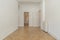 Empty living room with metal radiator, oak parquet