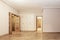 Empty living room with white built-in wardrobe, access doors