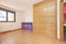 Empty living room with wooden floor, white painted walls, brown aluminum