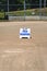 Empty local baseball field on a sunny day, view of pitcherâ€™s mound and home plate, Field Reserved sign