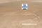 Empty local baseball field on a sunny day, view of pitcherâ€™s mound and home plate, Field Reserved sign