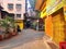 An empty lonely street with yellow shops and plants in daylight in Bandra Mumbai India