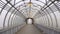 Empty long glass tunnel on the pedestrian bridge, The camera moves through glass tunnel on sunny day with blue sky, at