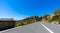 Empty long mountain road to the horizon on a sunny summer day at bright sunset