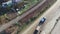 Empty lorry drives along road past railway and containers