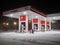 An empty Lukoil gas station on a winter night during heavy snowfall.