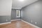 Empty luminous interior of an elegant modern colonial house with slick gray walls and a large window