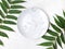 Empty marble plate with tropical leaves on white textured background. Minimalist summer table setting