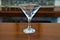 Empty martini glass on wooden bar counter detail